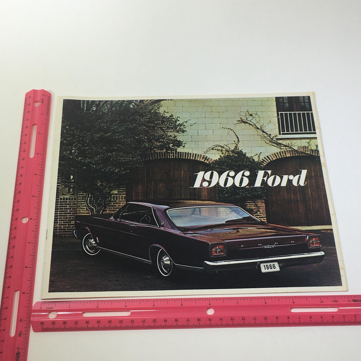 Back cover of the 1966 Ford 200-HP V-8 Engine Cruise-O-Matic Drive Die-Cast Grill Car Catalog with a maroon Ford car, highlighted with a ruler for size reference.