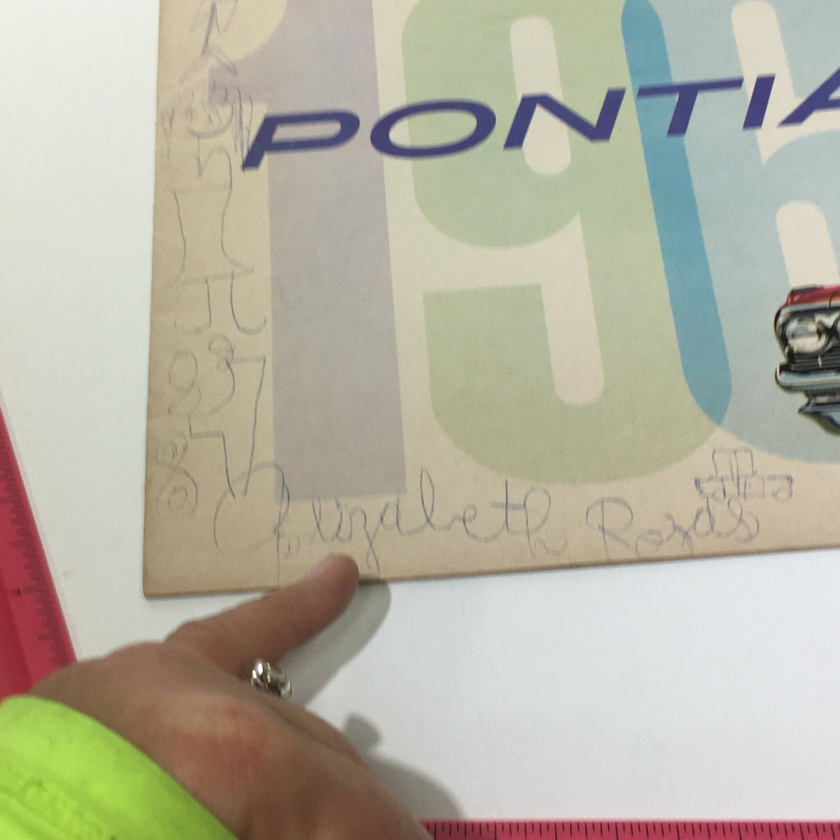 Close-up of the 1961 Pontiac Catalina Sport catalog cover with handwritten notes, highlighting the nostalgic character and personal touch of a classic car enthusiast.