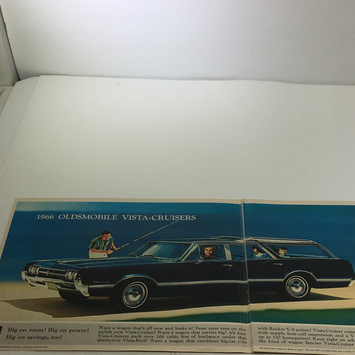 Interior page of the 1966 Oldsmobile Station Wagons Vista Cruisers brochure showcasing a sleek black Vista Cruiser parked with families enjoying the spacious interior.