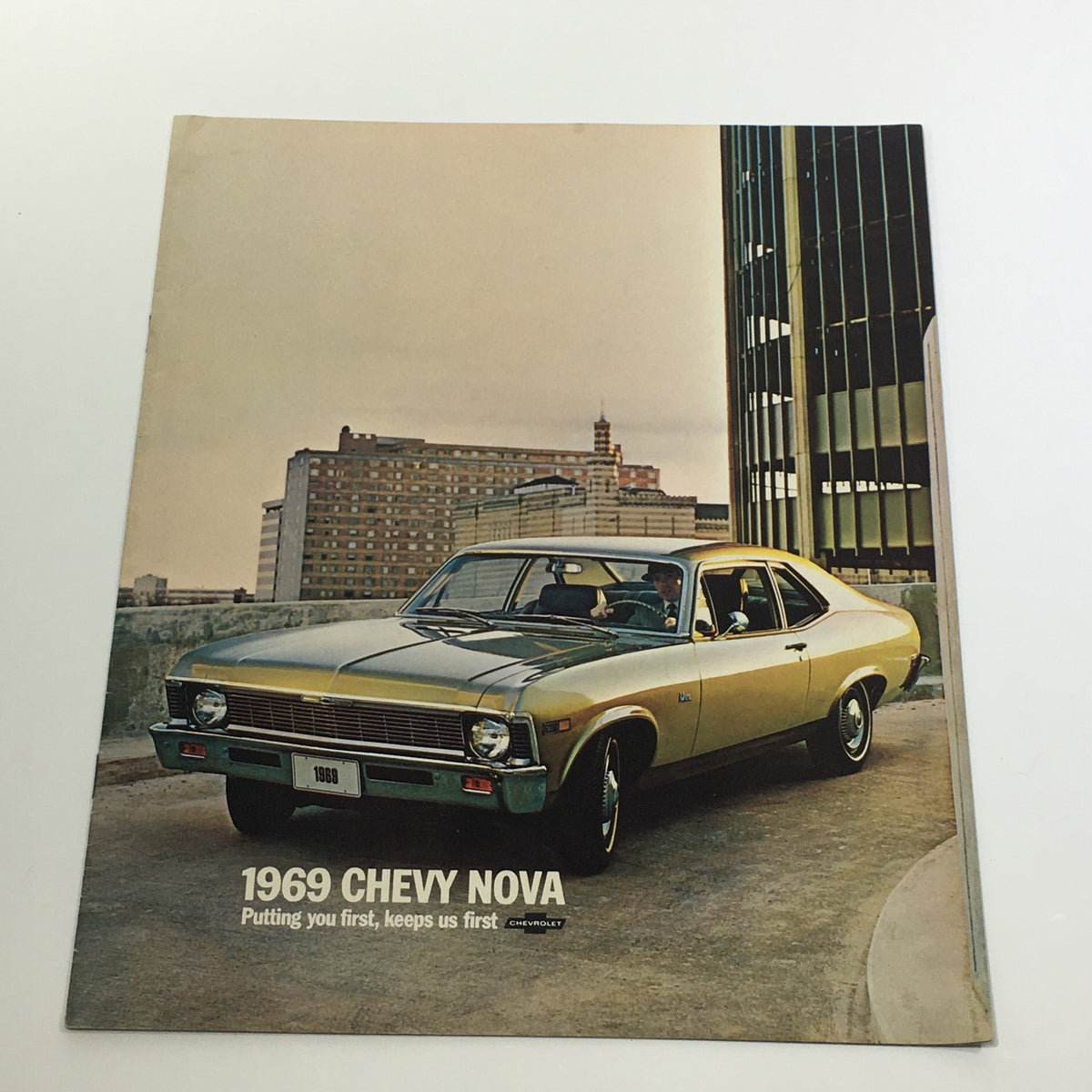 1969 Chevrolet Chevy Nova 2-Door Sedan SS Package Car Sale Brochure front cover showcasing the stylish design of the vehicle on an urban backdrop.