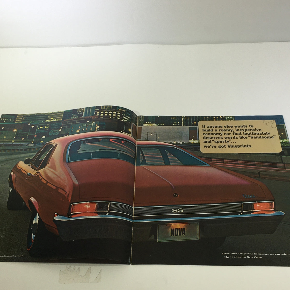 Interior page of the 1969 Chevrolet Chevy Nova 2-Door Sedan SS Package Car Sale Brochure featuring the rear view of a red Nova with city lights in the background.