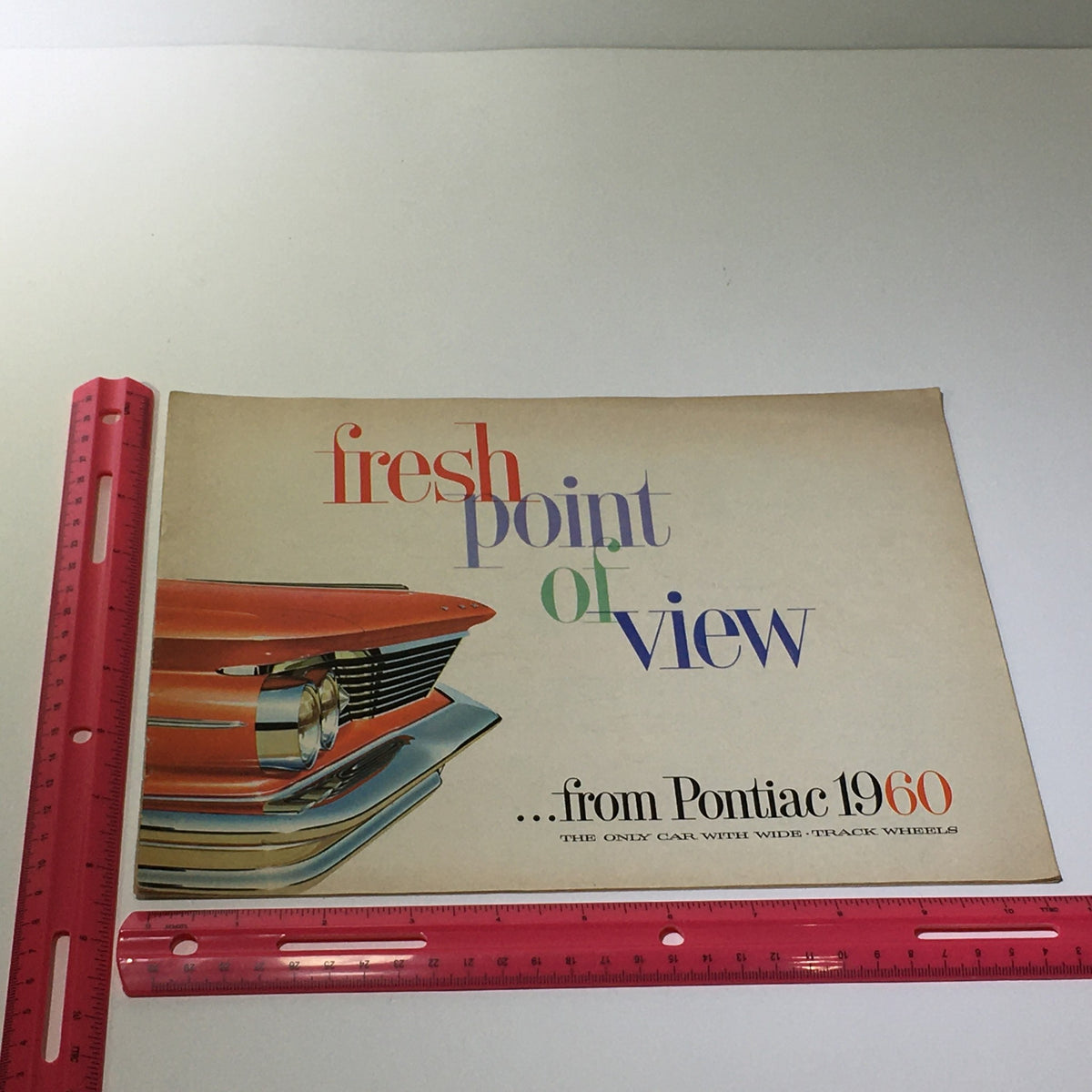 Cover of the 1960 Pontiac Fresh Point of View Catalina brochure shown with a ruler for size reference.