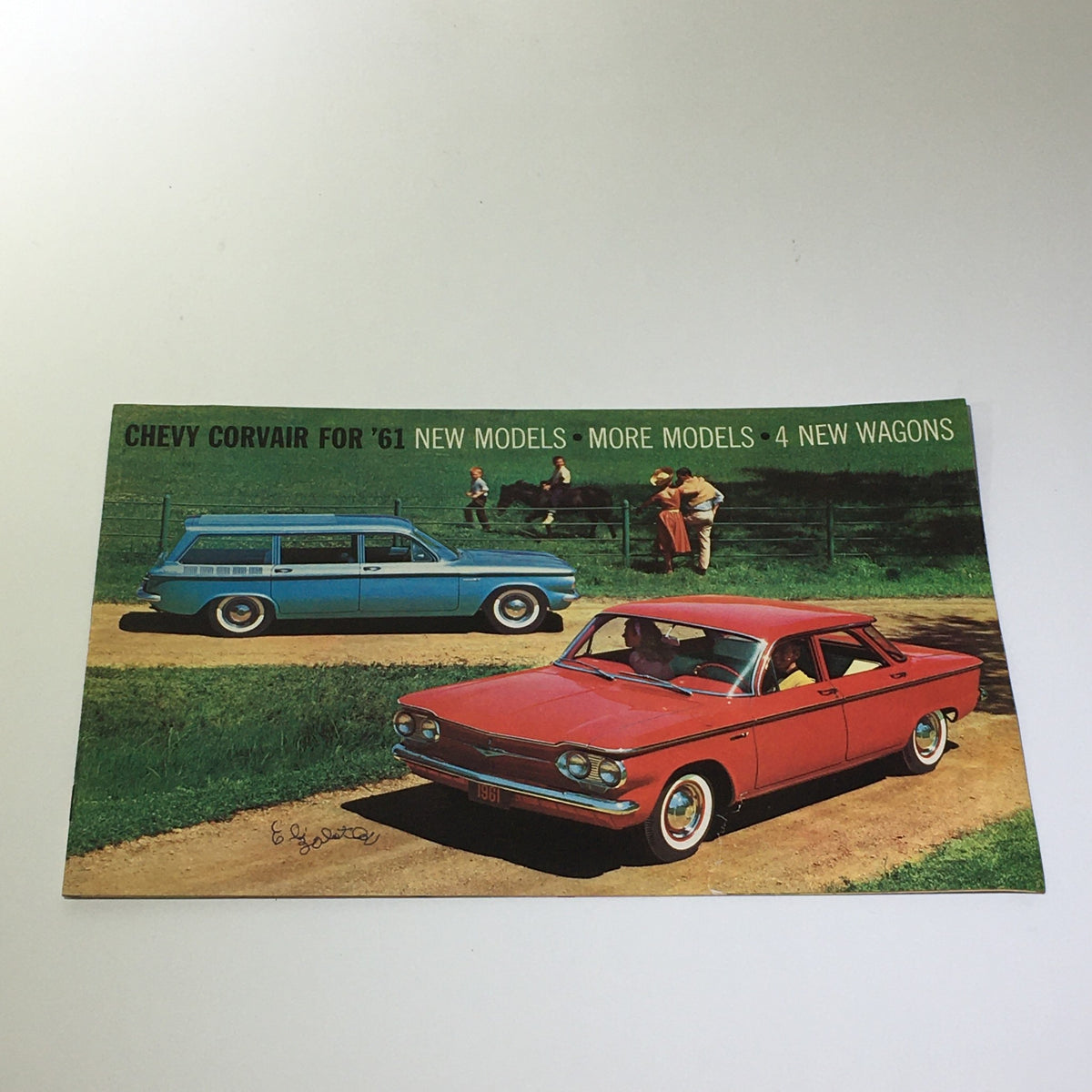 1961 Chevy Corvair 4 New Wagons Lakewood 700 Catalog featuring a vibrant image of a red and blue Chevy Corvair station wagons on a scenic road.