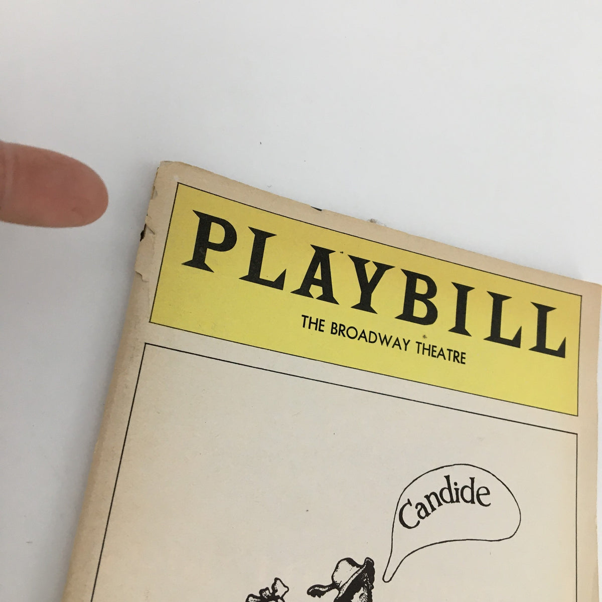 Close-up view of the top corner of the 1975 Playbill for The Broadway Theatre 'Candide' showing minor wear.