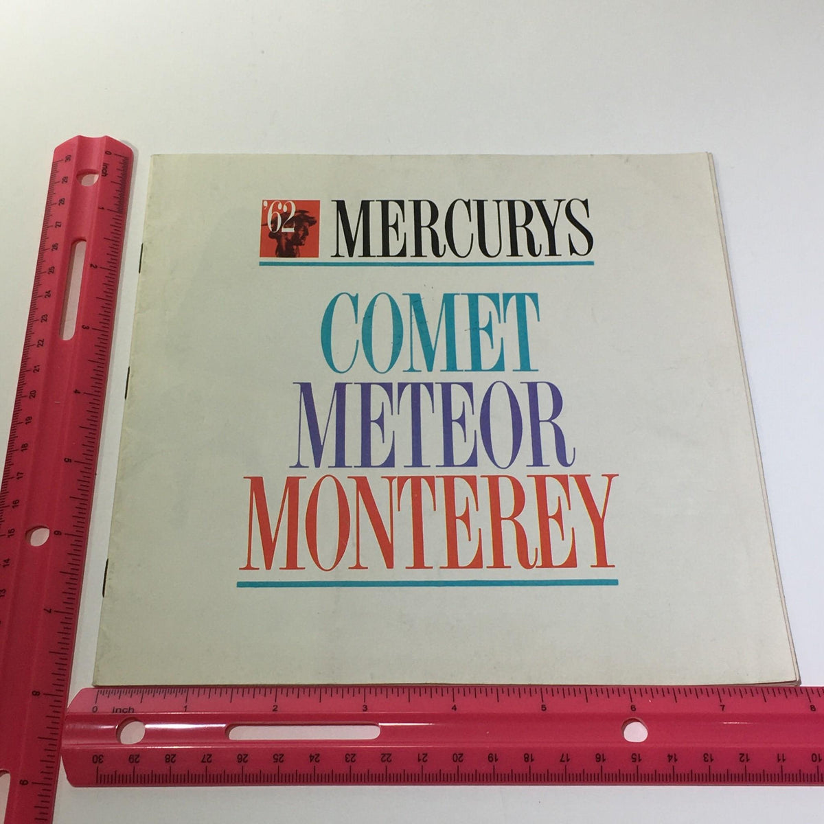 Cover of the 1962 Mercury's Comet Meteor Monterey V-8 Engine 2-Barrel Carburetor Car Catalog shown alongside a ruler for size reference.