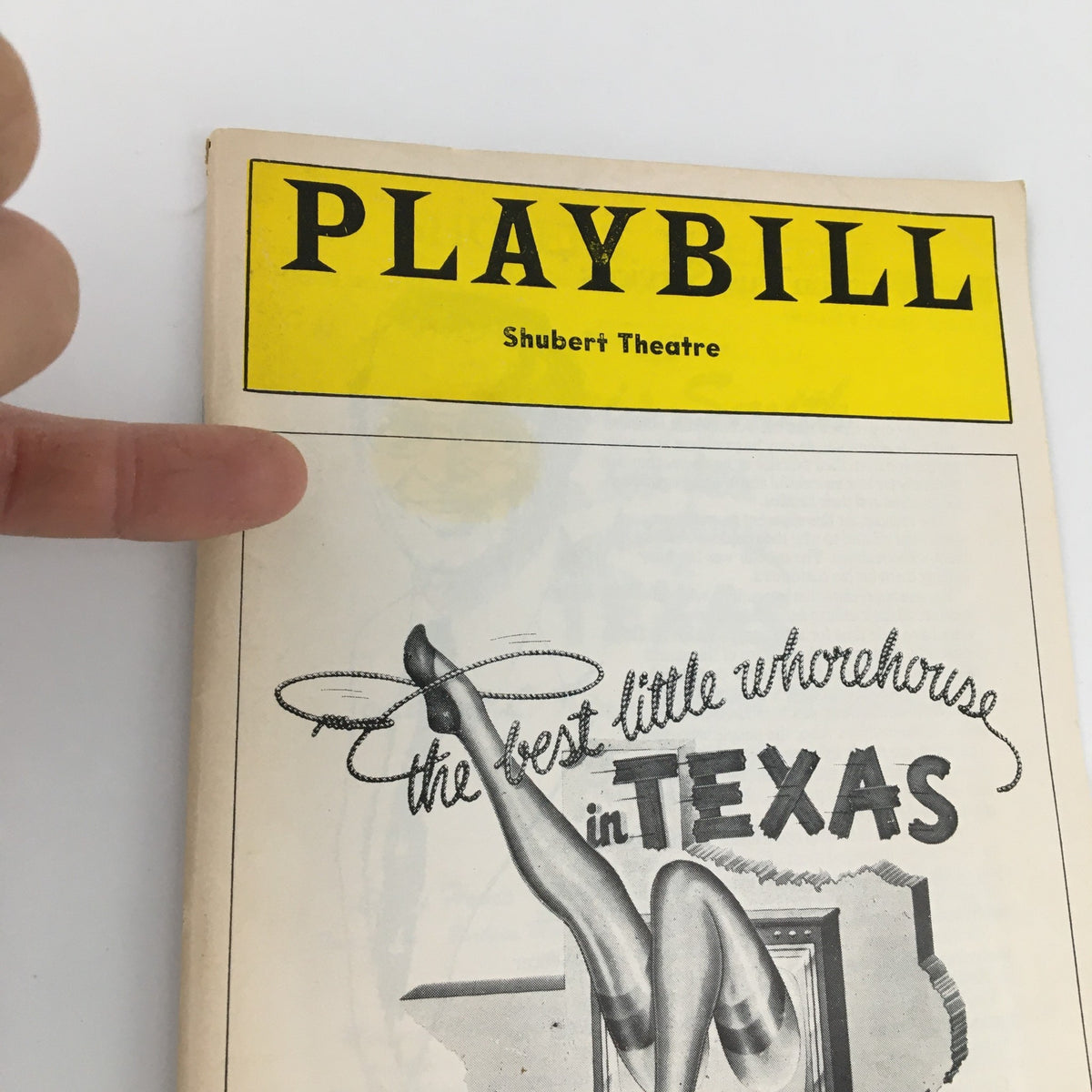 Close-up view of 1978 Playbill from Shubert Theatre for 'The Best Little Whorehouse in Texas,' highlighting the title and design detail.