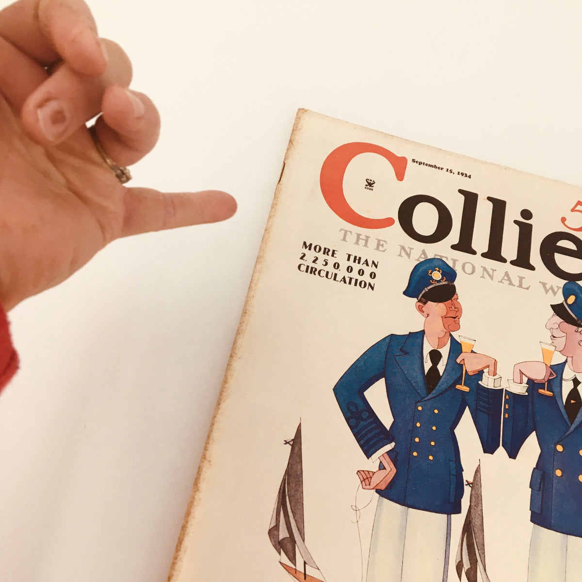 A close-up view of the cover of the VTG Collier's Magazine from September 15, 1934, highlighting the article 'Who Rules Germany?' by T.R. Ybarra, with a hand on the edge emphasizing the decorative illustrations.