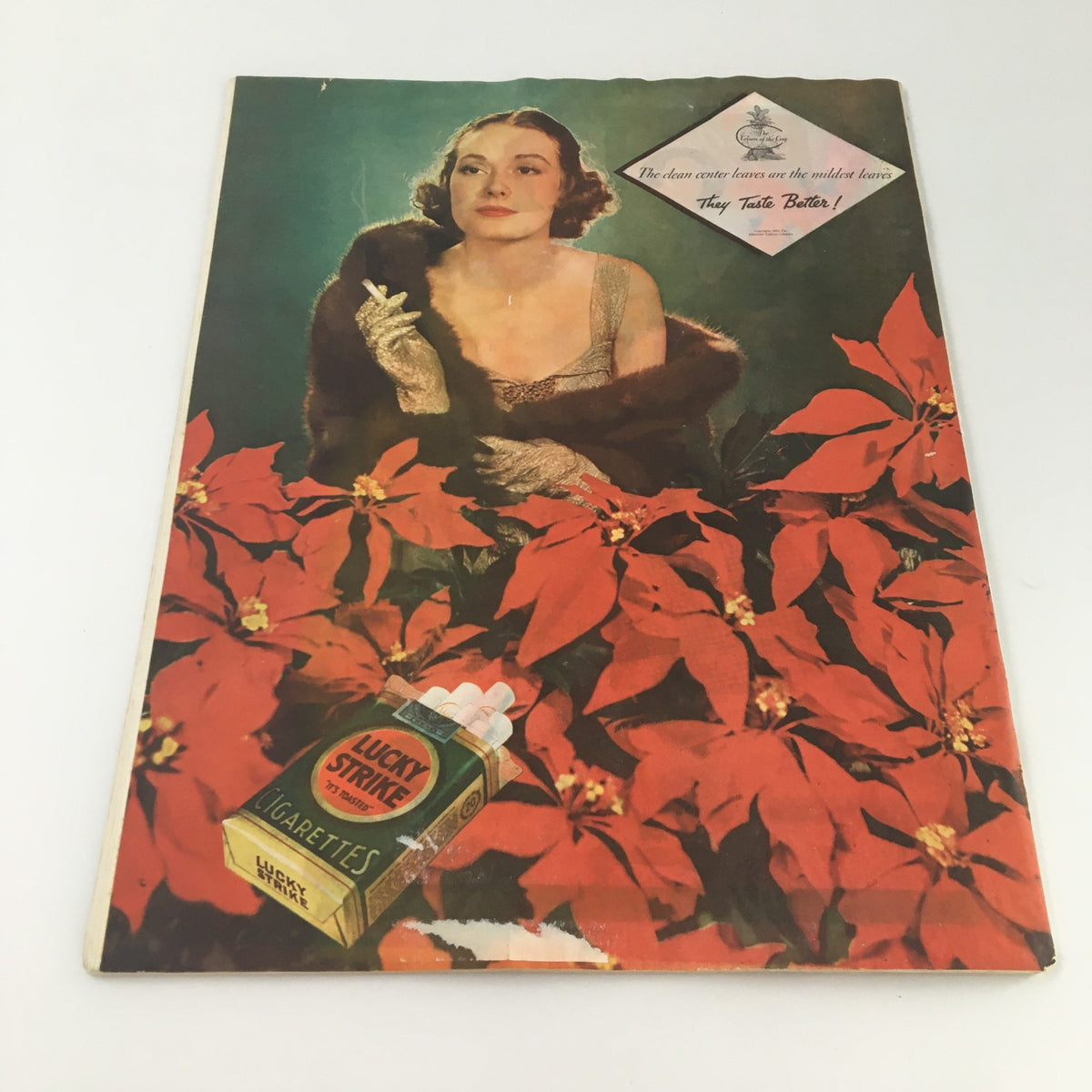 Back cover of the VTG Collier's Magazine December 15, 1934, featuring a woman with a cigarette and a Lucky Strike cigarette advertisement surrounded by vibrant poinsettias.