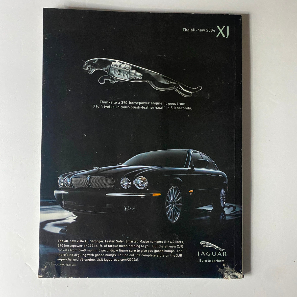 Back cover of Robb Report Car Magazine July 2003 showcasing the 2004 Jaguar XJ with a sleek design and powerful engine features.