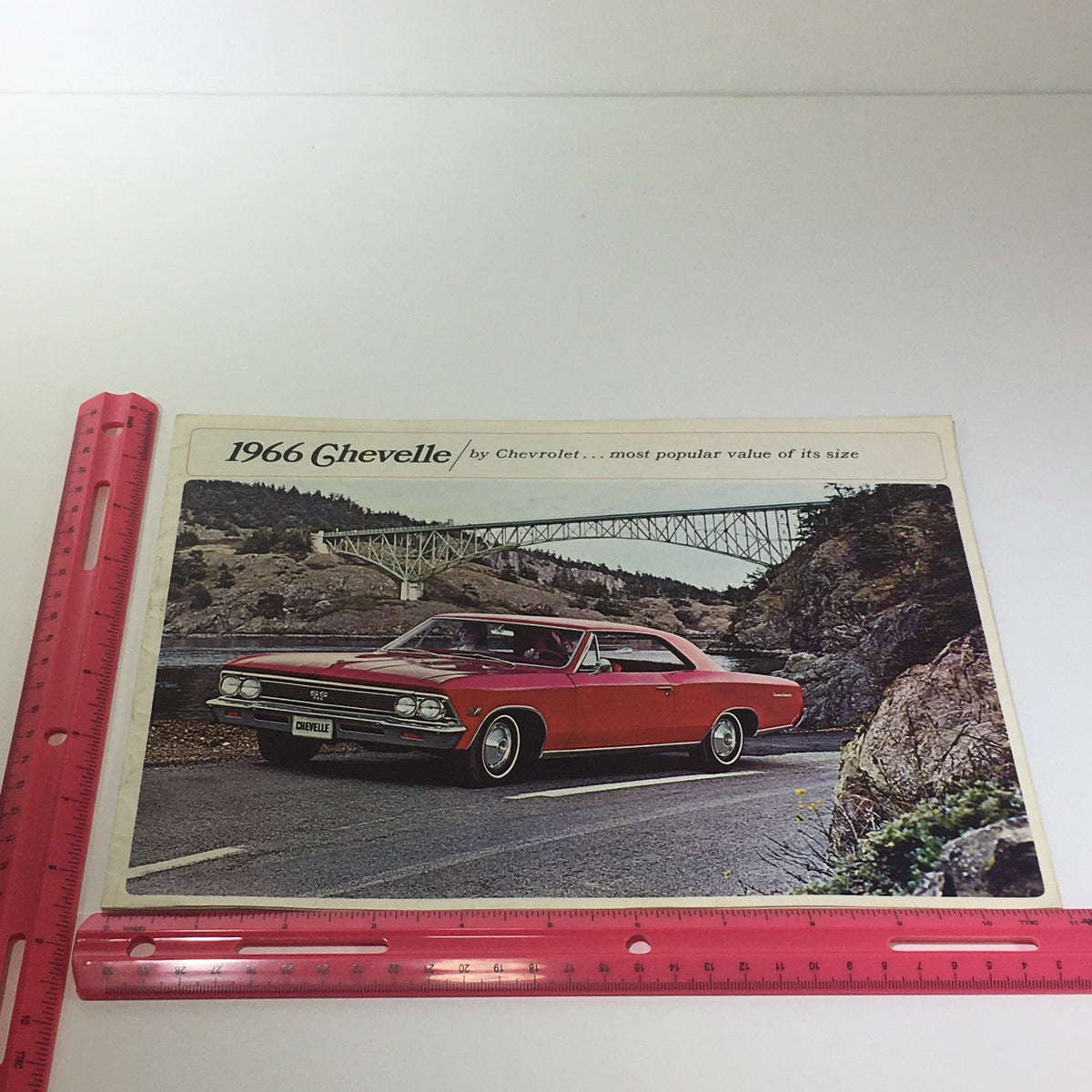 1966 Chevelle 300 Deluxe 2-4 Door Sedan/Super Sport 396 Coupe Chevrolet Catalog featuring a classic red Chevelle driving along a scenic mountainous road with a bridge in the background.