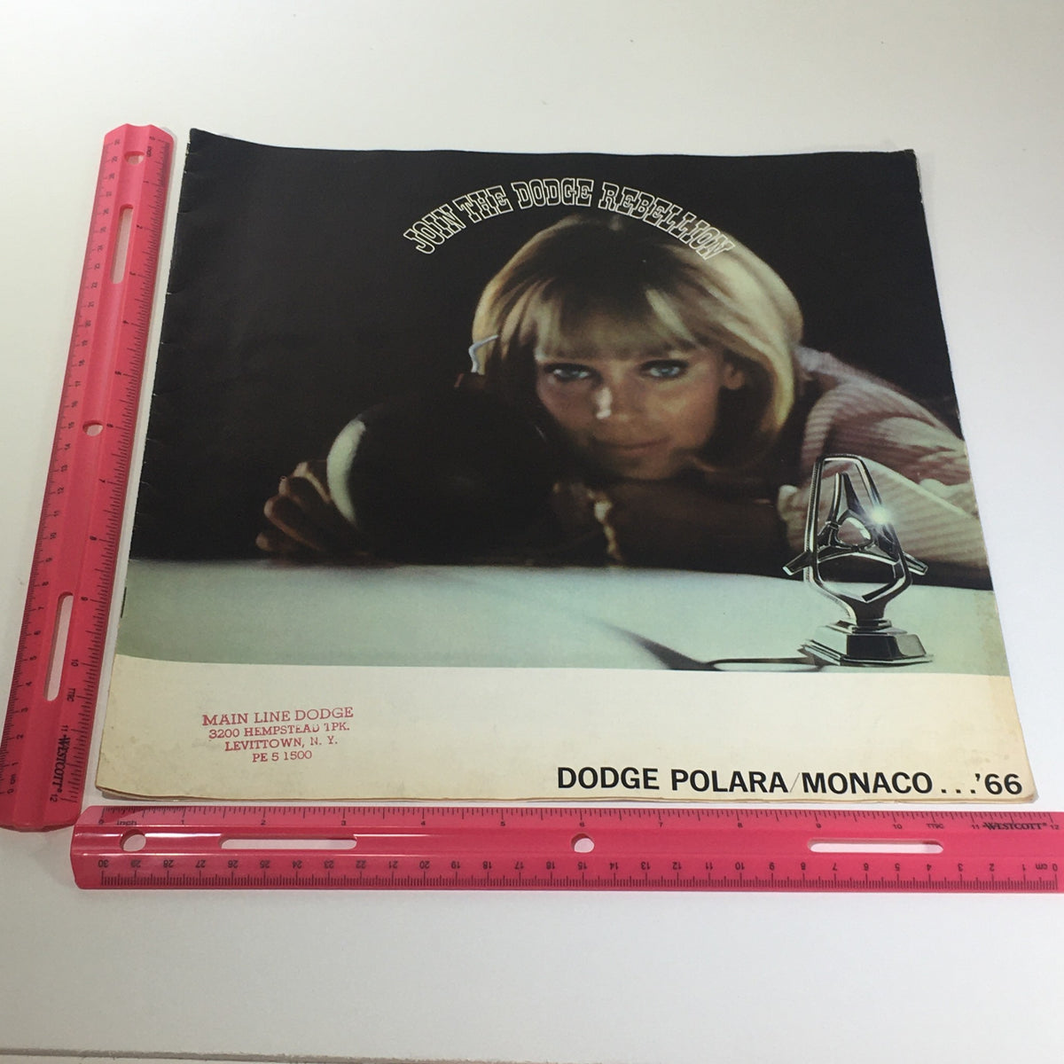1966 Dodge Polara Monaco by Chrysler 2-Door Convertible Car Catalog Brochure featuring a vintage design with a woman resting her head on a surface, showcasing promotional art under the title 'Join the Dodge Rebellion'.