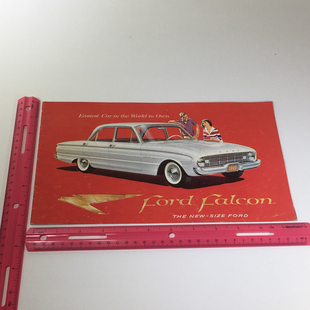1960 Ford Falcon The New-Size 4-Door 90-HP 144CU Falcon Six Car Catalog Brochure front cover featuring silver Falcon car and colorful design.