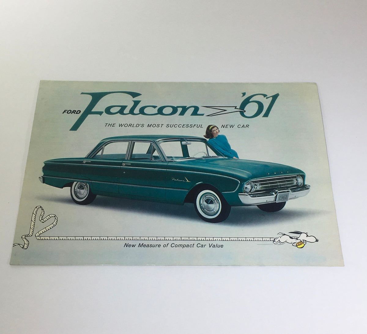 1961 Ford Falcon Fordomatic 2-Speed car catalog brochure cover featuring a teal Ford Falcon with a woman standing beside it.