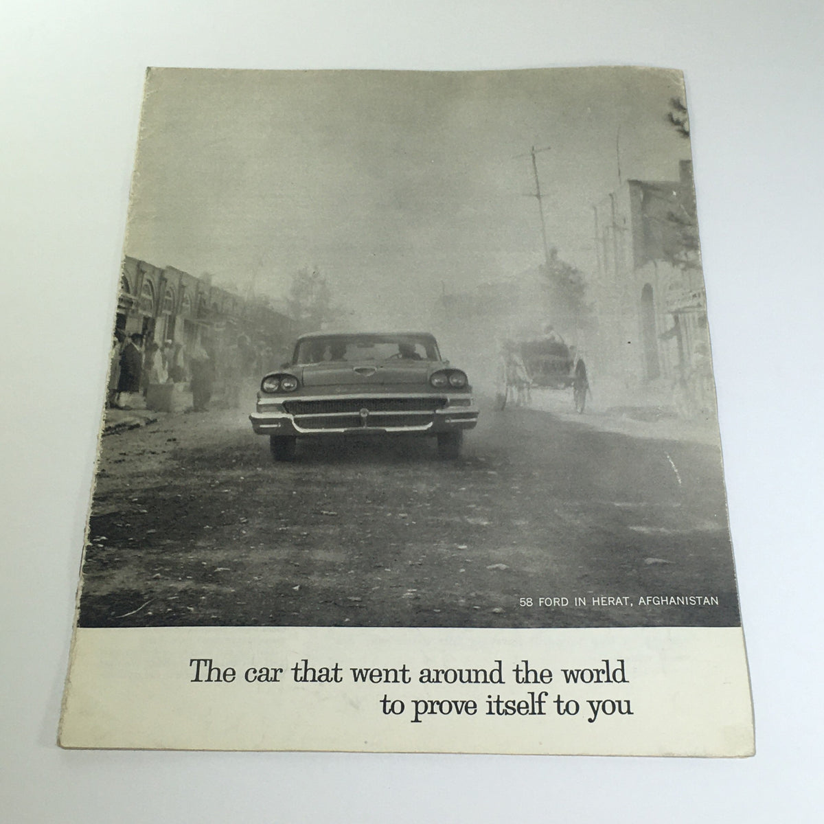 1958 Ford 2-Door Sedan Hardtop Russian Frontier Car Catalog Brochure depicting a classic car on a dusty street in Herat, Afghanistan, showcasing its global appeal.