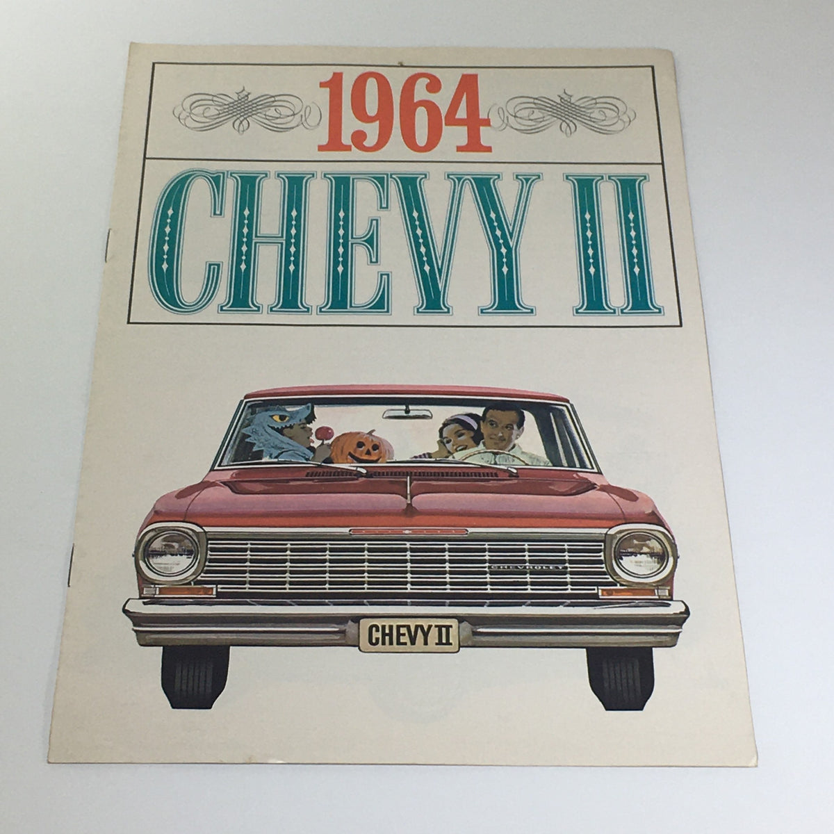 1964 Chevy II 100 brochure featuring a colorful illustration of a red Chevy II car with animated characters and people in the front seat, highlighting the Nova models by Chevrolet, in excellent condition.