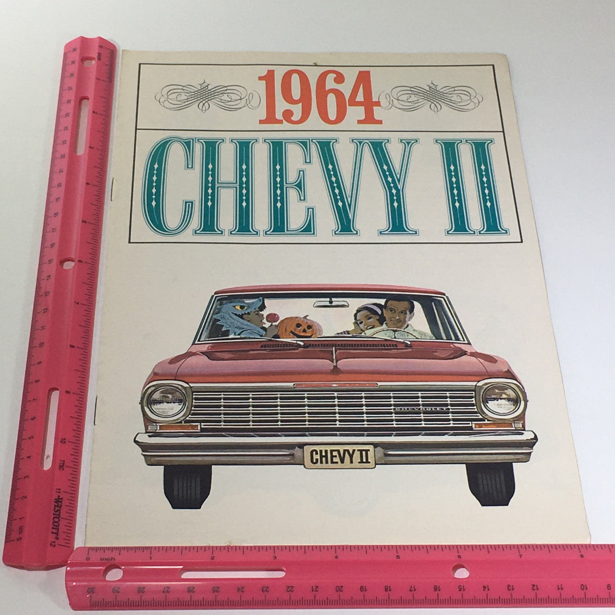 Cover page of the 1964 Chevy II 100 - Nova Models by Chevrolet brochure featuring a family in a red Chevy II car. The illustration evokes a sense of fun and adventure, capturing the essence of the Chevy II experience.