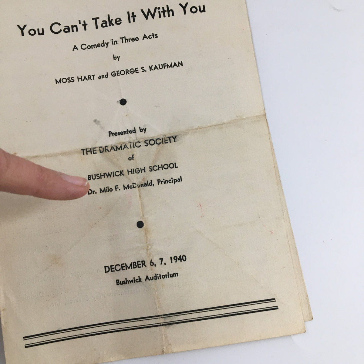 Close-up of the 'You Can't Take It With You' program from the 1940 Bushwick Auditorium, highlighting the presenters, Bushwick High School, and featuring Moss Hart and George Kaufman.