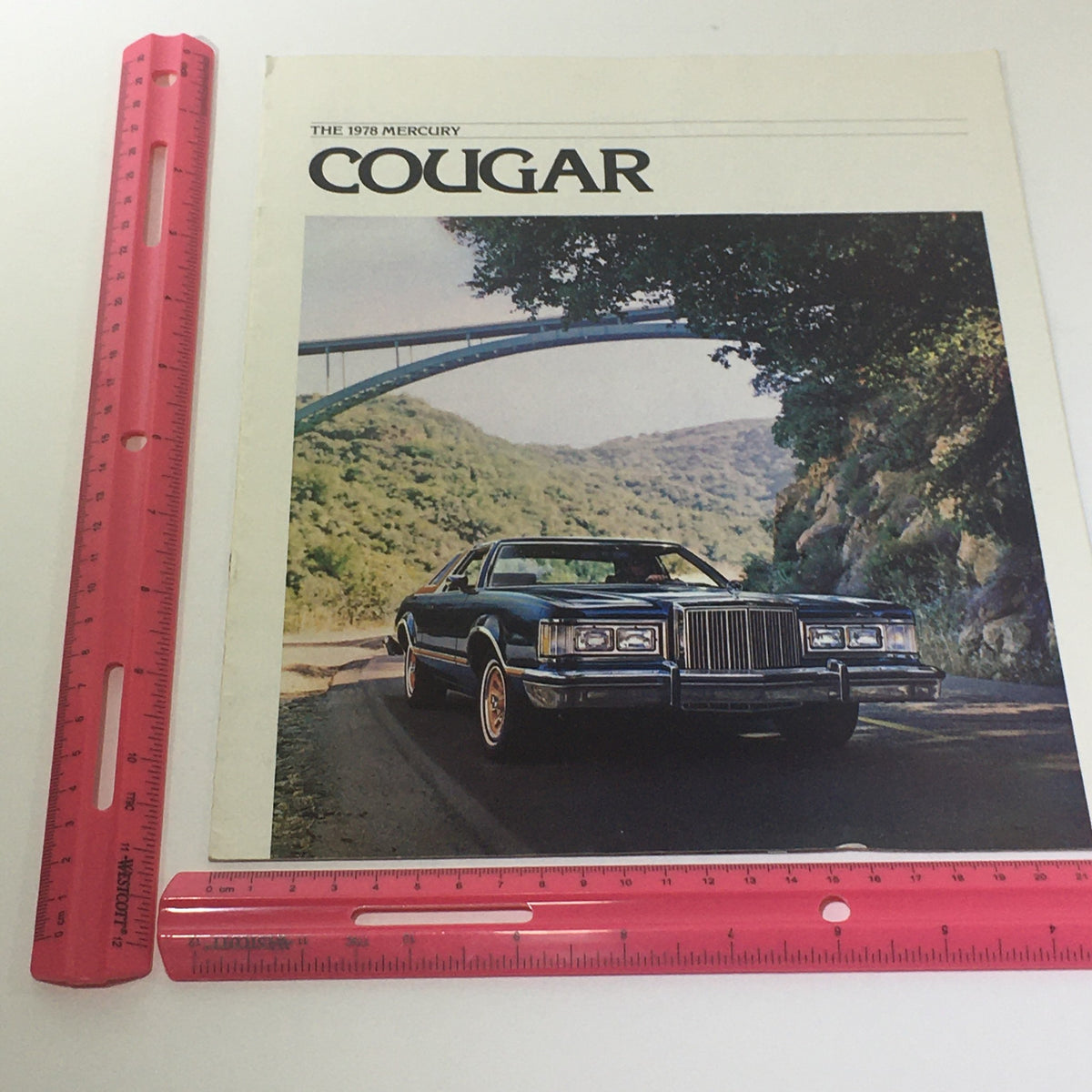 Vintage 1978 Mercury Cougar XR-7 catalog displayed with a ruler for size reference, highlighting the car's iconic cover art.