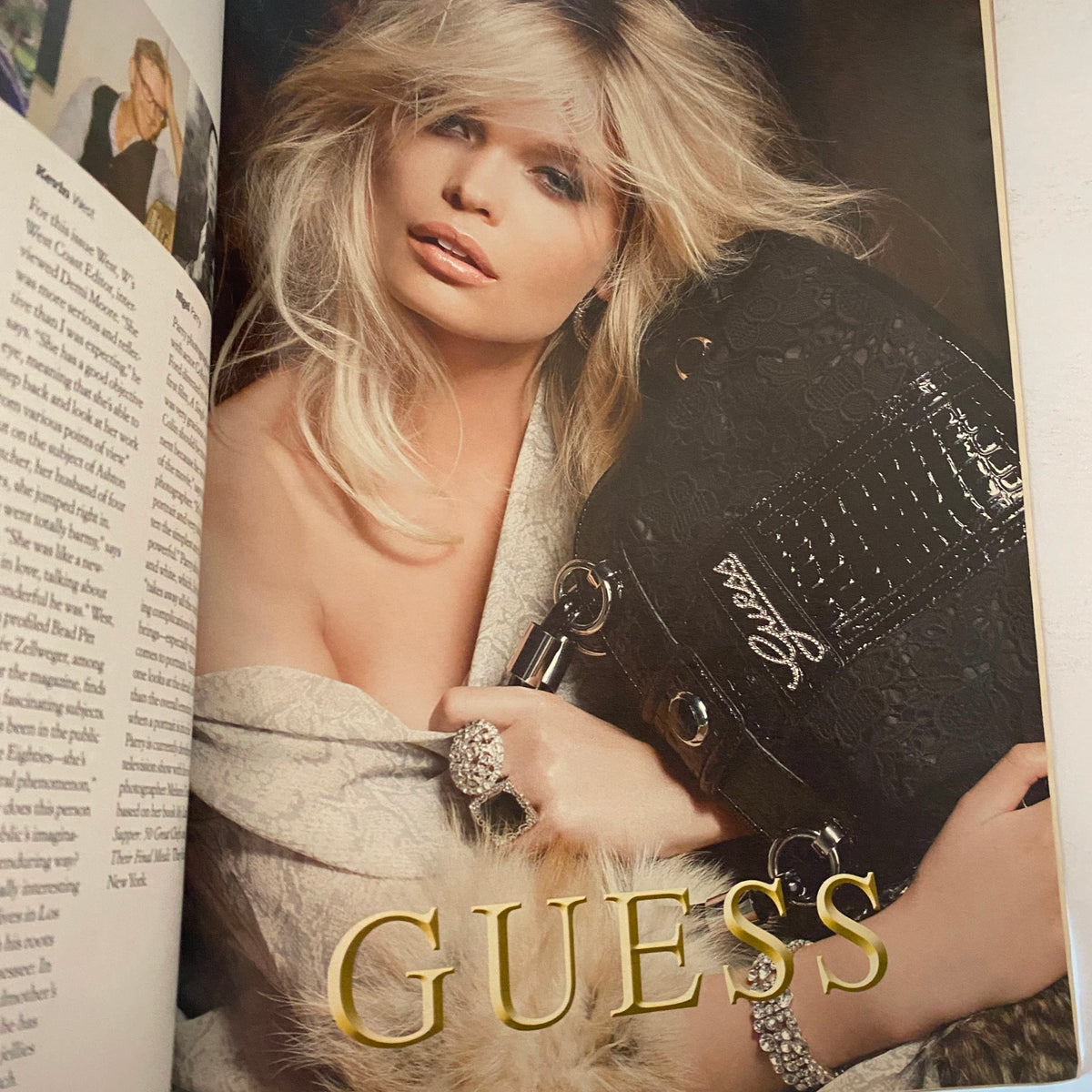Another interior page of W Magazine December 2009 with a fashion spread featuring model interacting with Guess accessories.