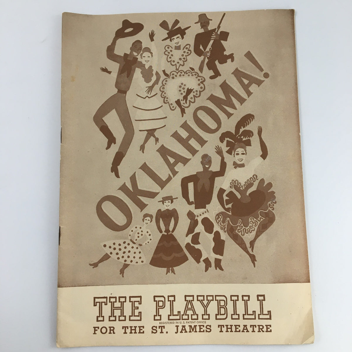 1945 Playbill from the St. James Theatre for 'Oklahoma,' featuring vintage illustrations of characters and the title prominently displayed.