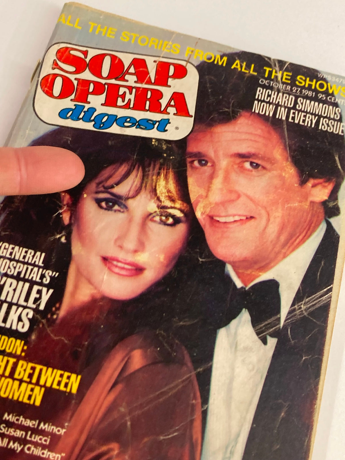 Close-up of the cover of VTG Soap Opera Digest October 27 1981 with a finger pointing at the details, highlighting Michael Minor and Susan Lucci.