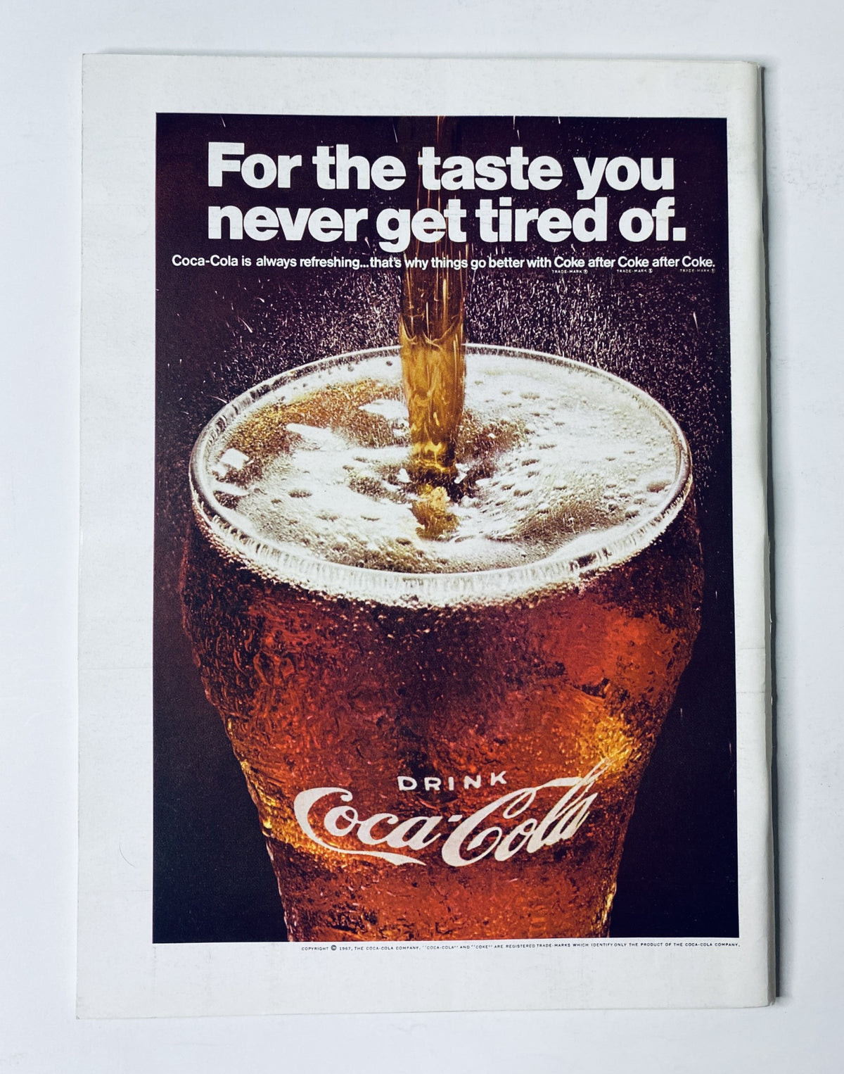 A vintage Coca-Cola advertisement featuring a glass of Coca-Cola with the tagline 'For the taste you never get tired of.' The image showcases the refreshing nature of the drink and complements 'The New Yorker Magazine June 17, 1967 Rainbow Birds Fantasy Cover A. François VG' for sale.