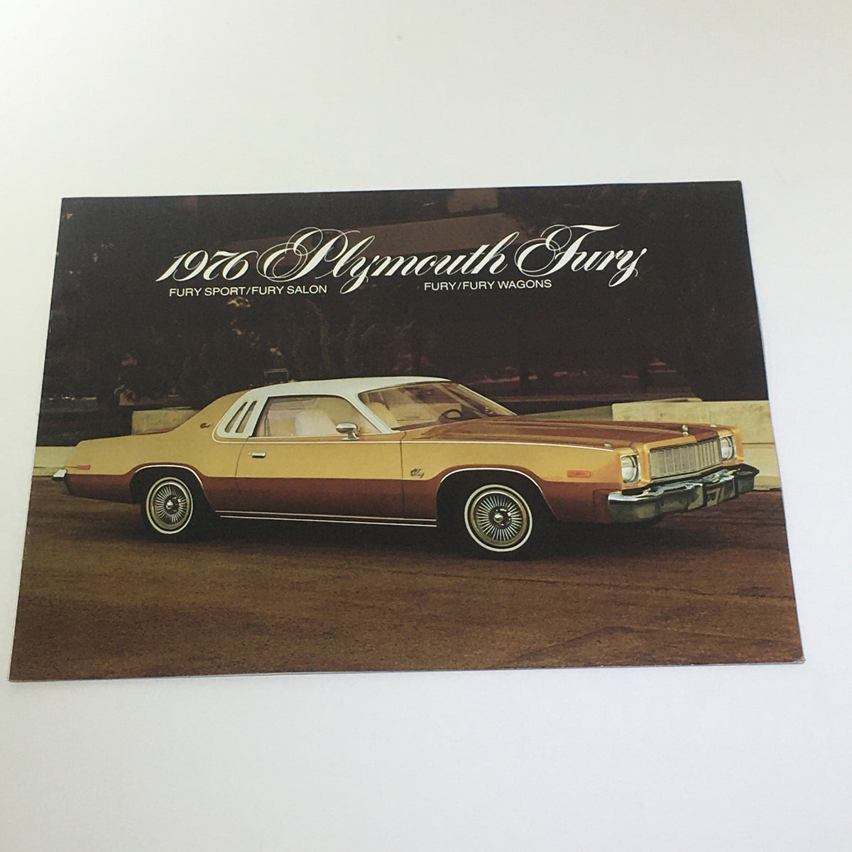 Vintage 1976 Plymouth Fury Fury Sport/Salon/Wagons brochure featuring a classic orange Plymouth Fury parked in a scenic location, showcasing its iconic design.