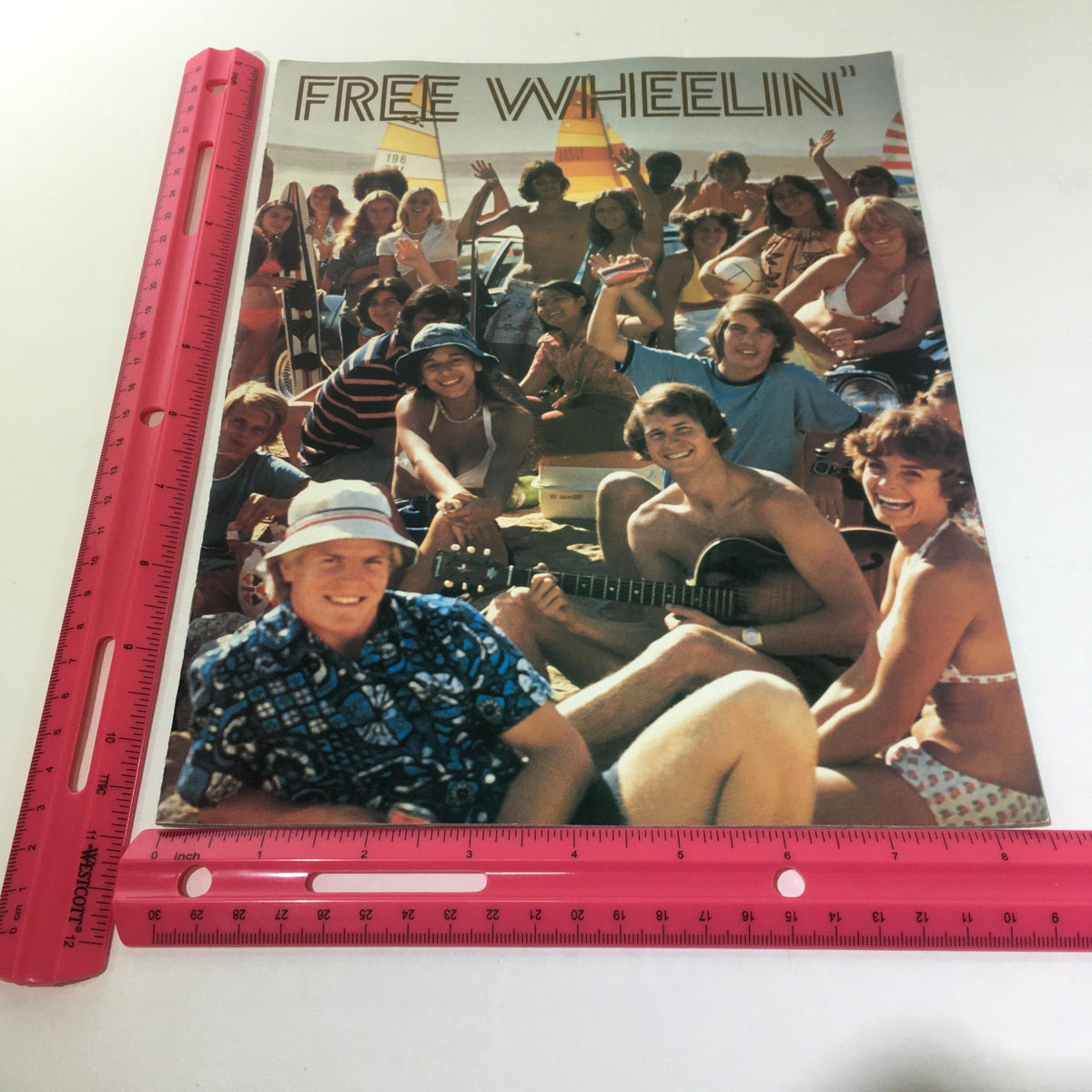 Vintage Free Wheelin' Mustang II MPG 2+2 Stallion-1965 Shelby Cobra Car Brochure showcasing a lively group of young people at a beach, capturing the essence of 1970s summer fun.