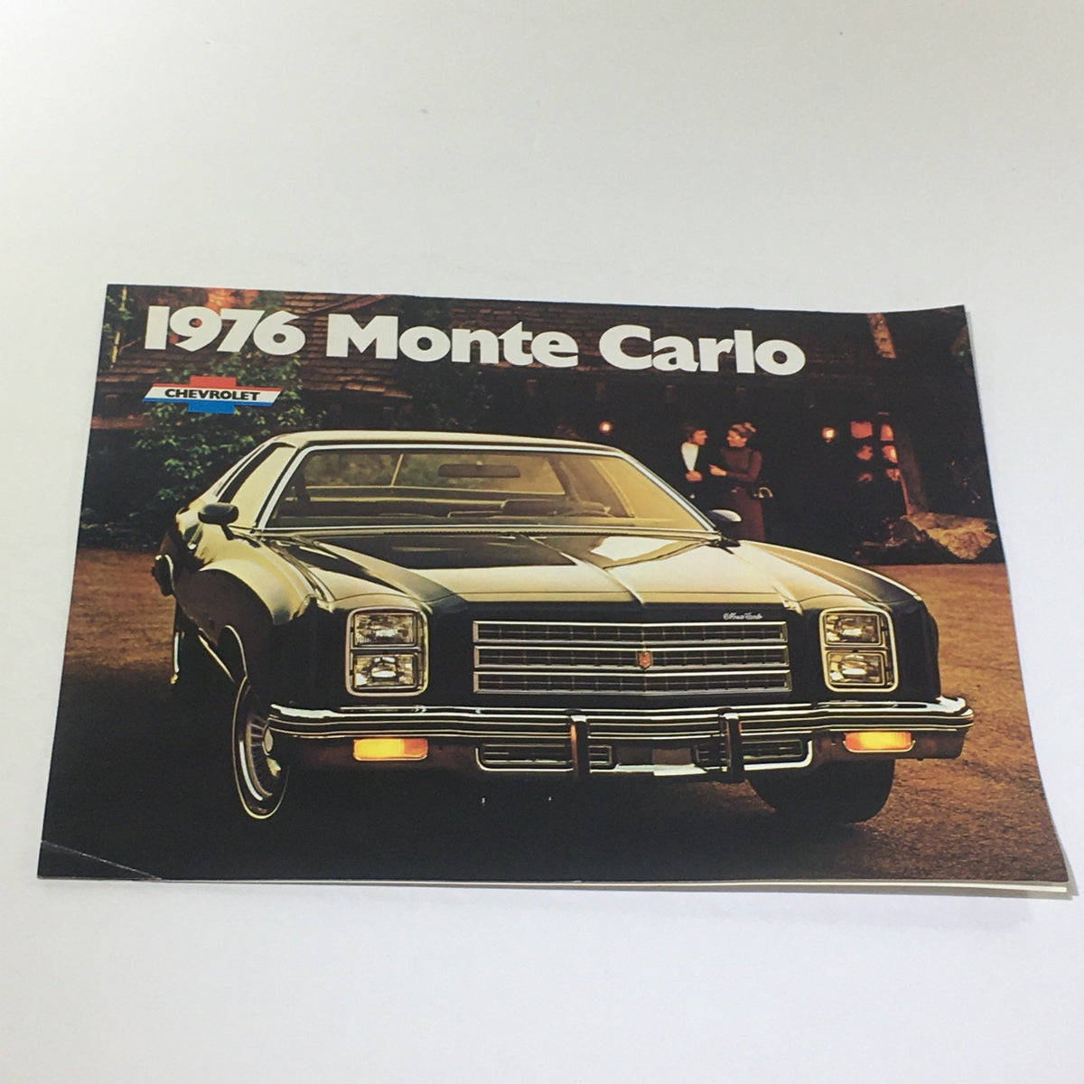 Vintage 1976 Monte Carlo Landau Coupe by Chevrolet 2-Door Hardtop car brochure featuring the iconic Monte Carlo design, showcasing the sleek front view of the vehicle against a backdrop.