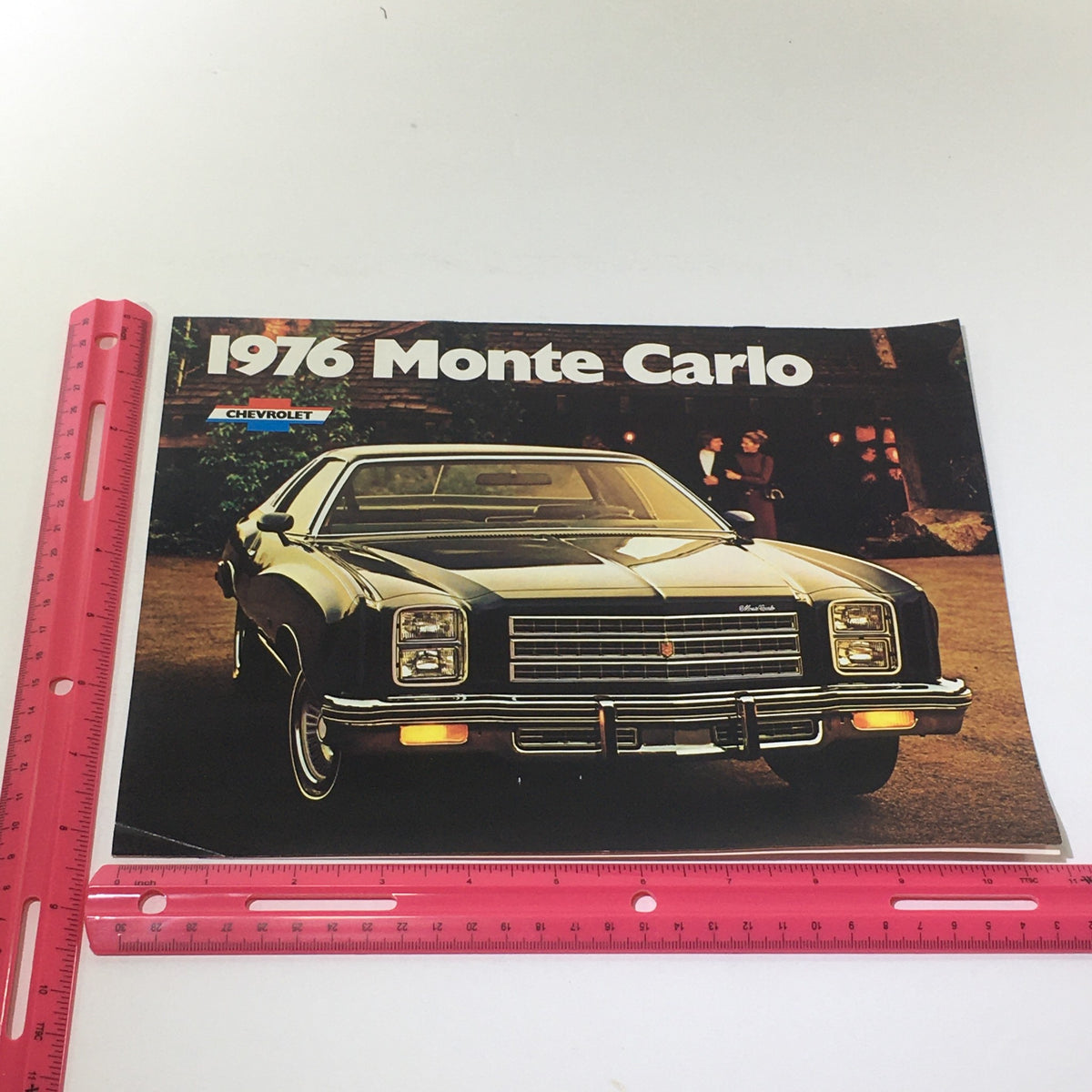 Front cover of the 1976 Monte Carlo Landau Coupe by Chevrolet brochure featuring the car prominently with a ruler for size reference.