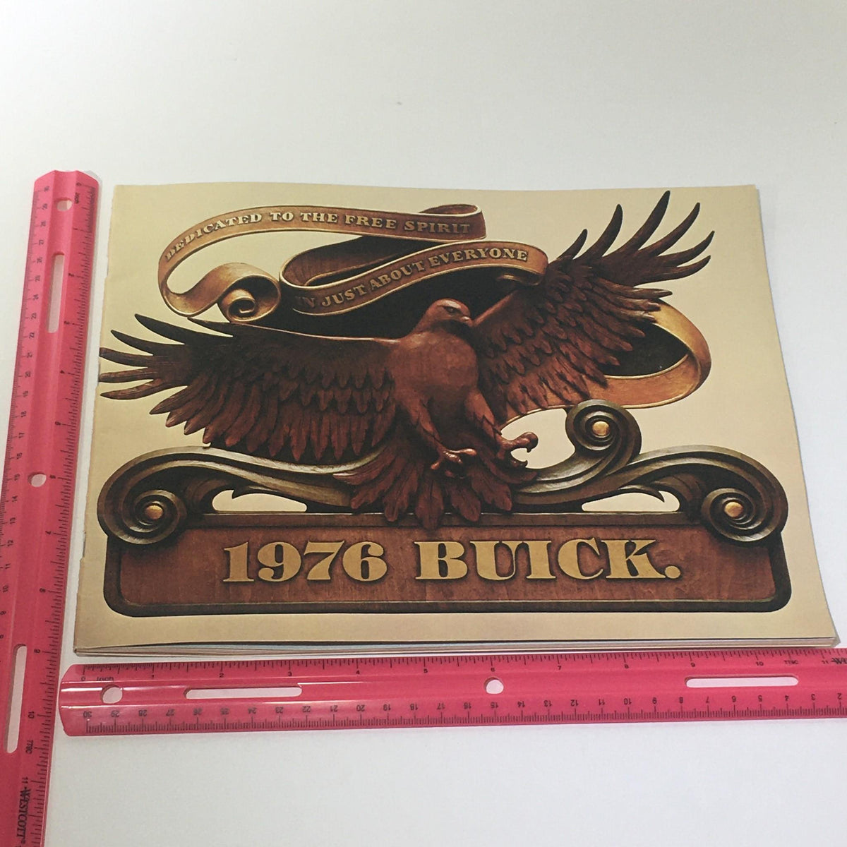 Cover of the Vintage 1976 Buick The Century Coupe Powered V-6 Engine 3.8 Liter Car Catalog featuring an elegant design with an eagle and the text '1976 BUICK' against a decorative background.