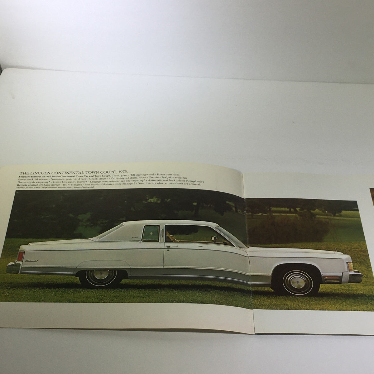 Interior page of the Vintage The 1975 Continentals Town Coupe/Town Car/Mark IV Car Catalog Brochure featuring an image of the Lincoln Continental Town Coupe in white against a green landscape.
