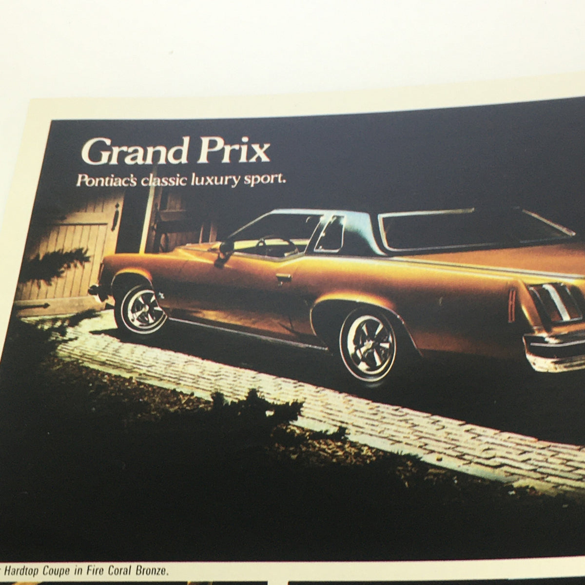 1974 Pontiac Grand Ville 4-Door Hardtop V-8 Sedan Car Auto Catalog Brochure featuring a Fire Coral Bronze Grand Prix, showcasing Pontiac's classic luxury sport car.