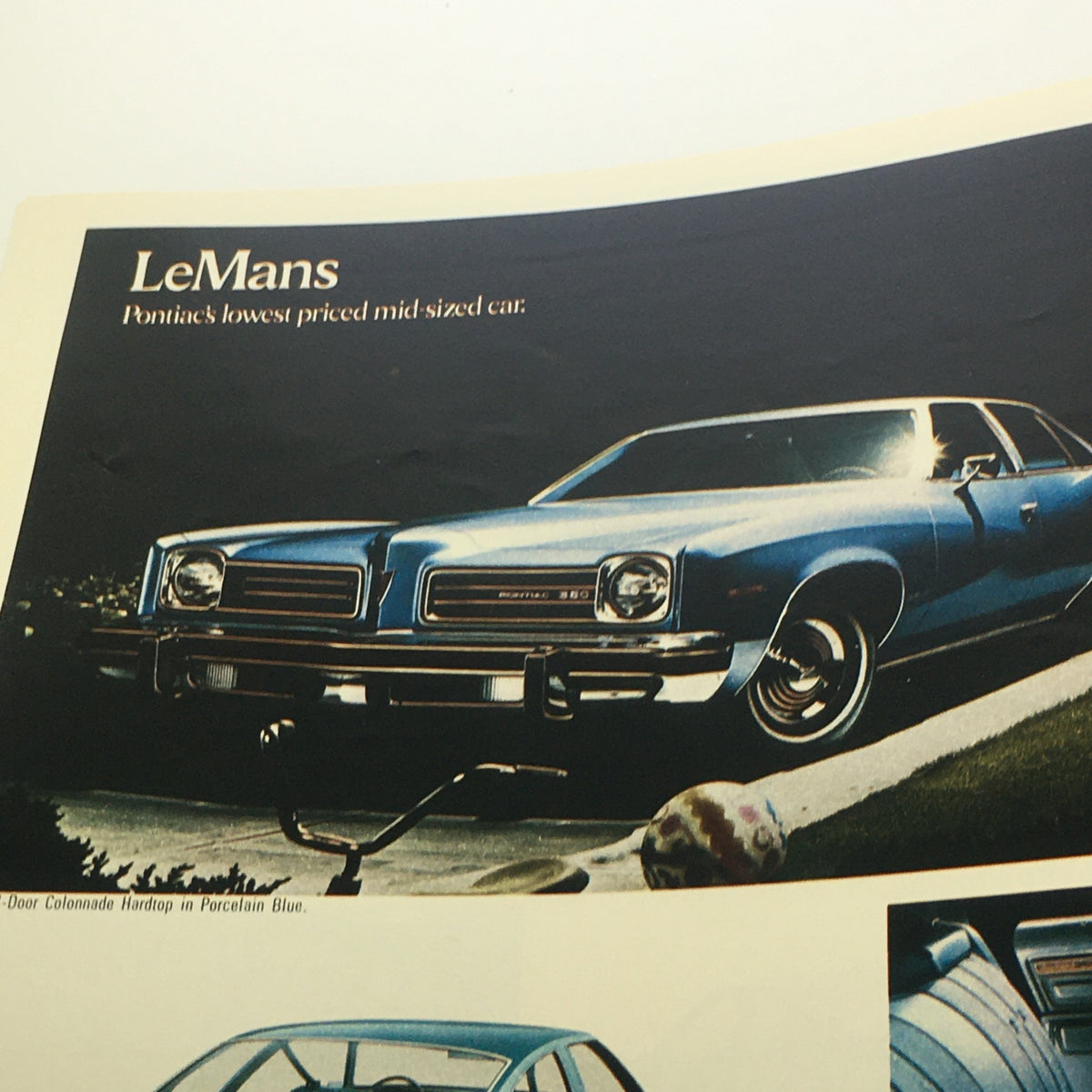 1974 Pontiac Grand Ville 4-Door Hardtop V-8 Sedan Car Auto Catalog Brochure featuring a blue LeMans, identified as Pontiac's lowest priced mid-sized car.