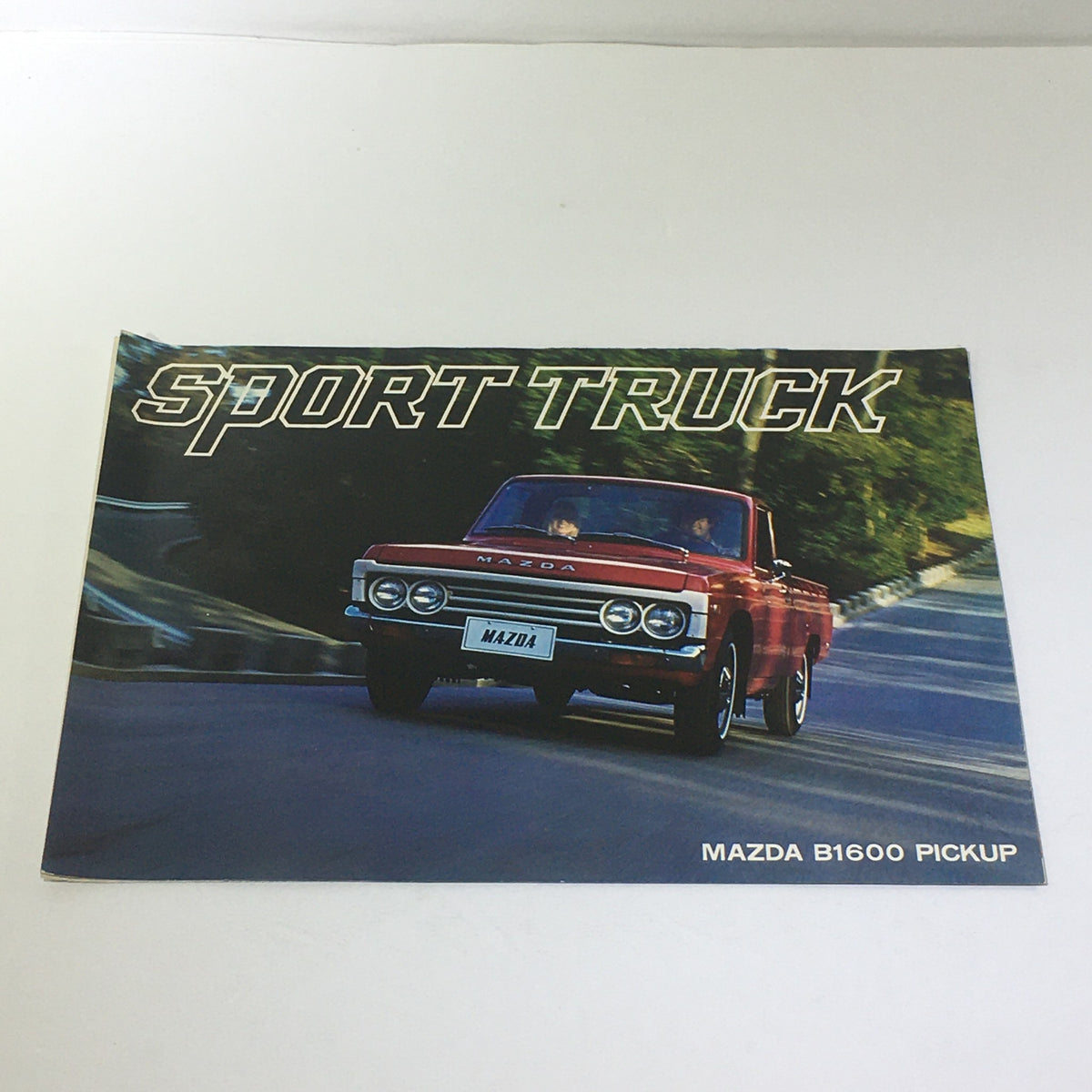1975 Mazda B1600 Pickup Sport Truck Car Auto Brochure Catalog, featuring a red Mazda B1600 Pickup on a scenic road, showcasing the front view with 'Sport Truck' prominently displayed.