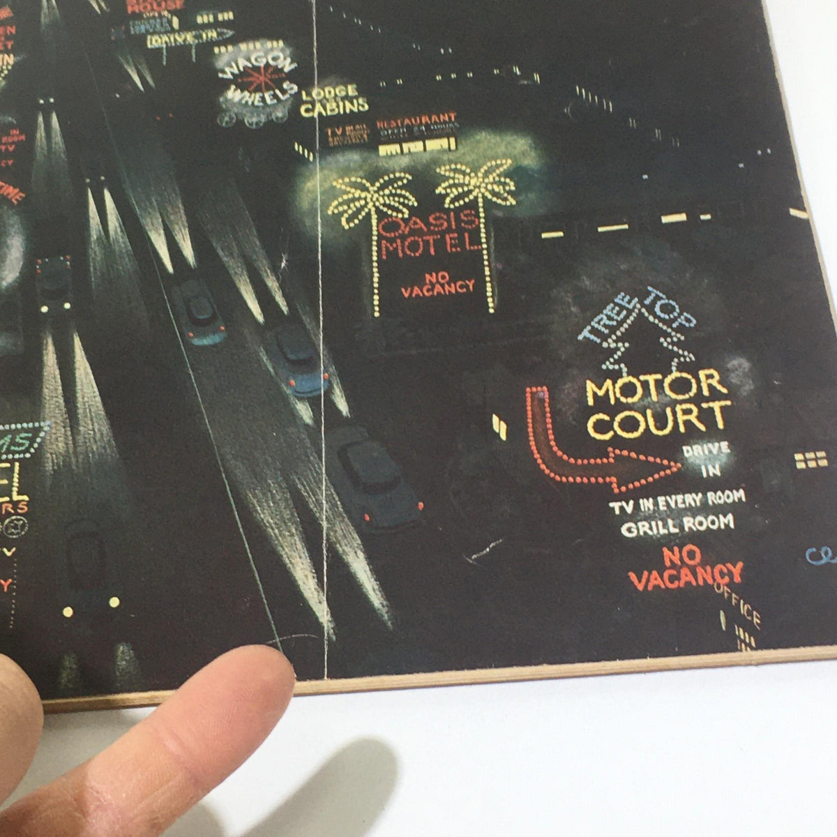 Detailed view of the cover of 'The New Yorker: July 25 1959' magazine, highlighting illuminated motel signs along a busy road.