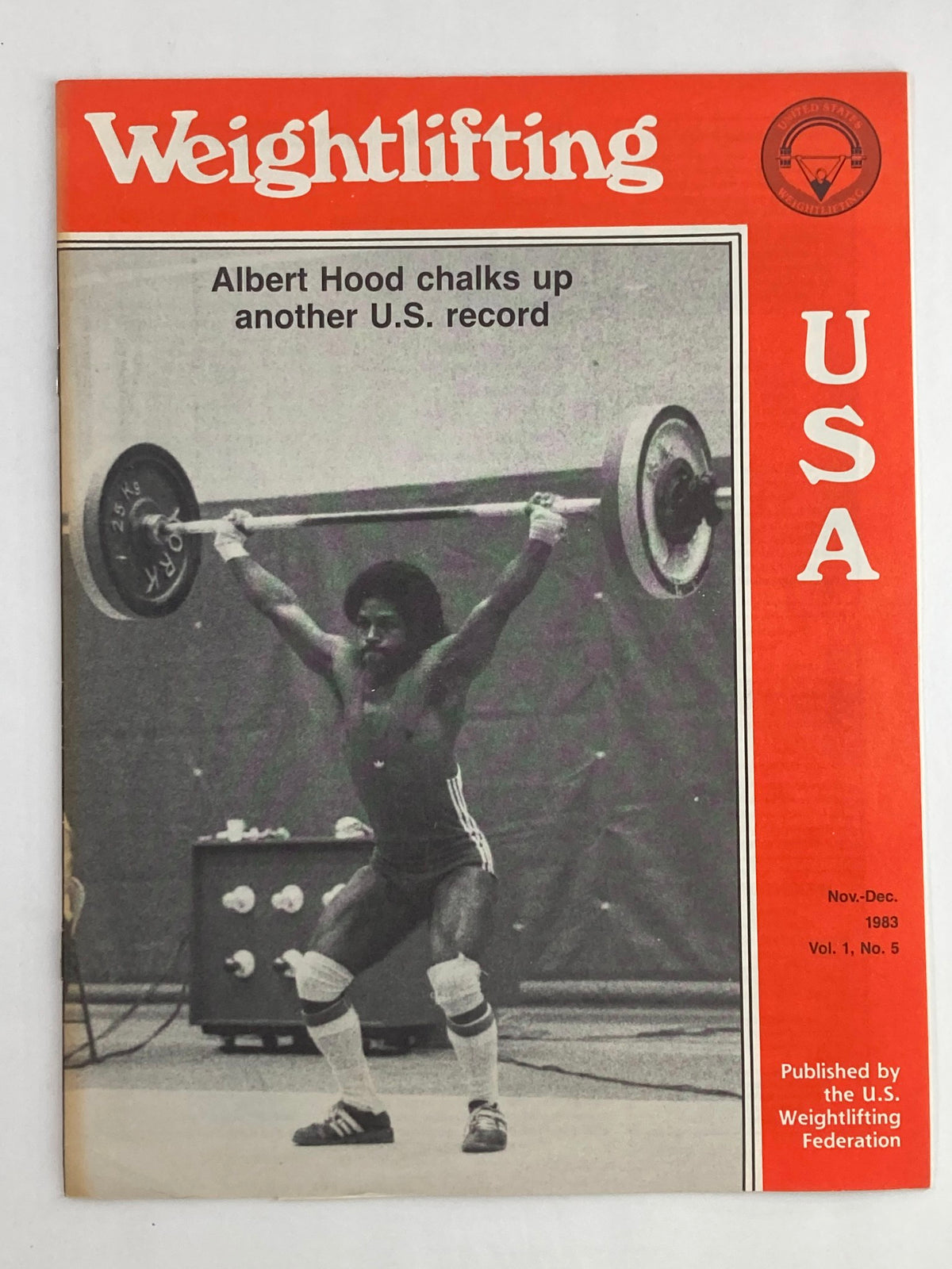 Cover of VTG Weightlifting USA Magazine Vol 1 #5 November 1983 featuring Albert Hood, showcasing a weightlifter performing a lift with vivid red and white design.