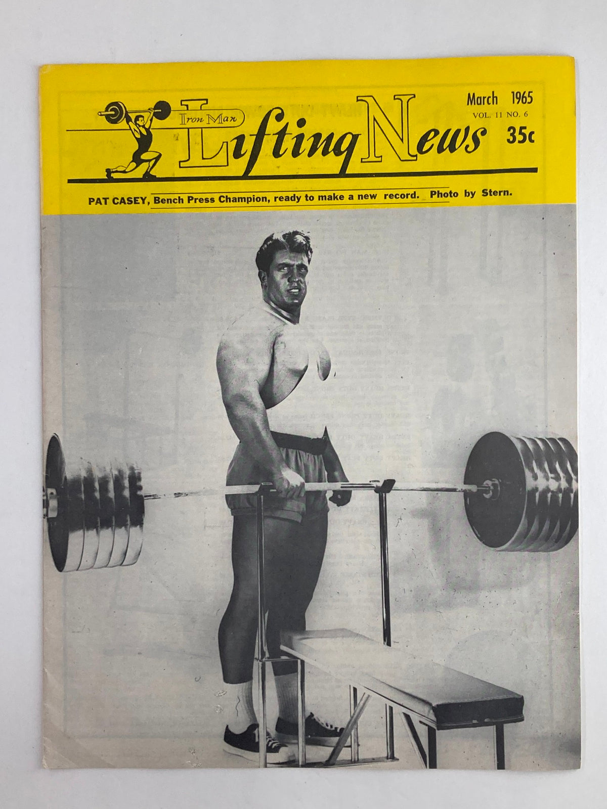 VTG Iron Man Lifting News Vol 11 #6 March 1965 featuring Pat Casey, Bench Press Champion, prepared to lift weights with a barbell on a bench; magazine cover showcases vintage fitness culture.