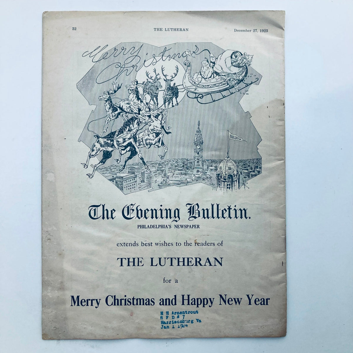 Advertisement page from VTG The Lutheran Magazine December 27 1923, extending Christmas wishes and featuring a festive illustration.