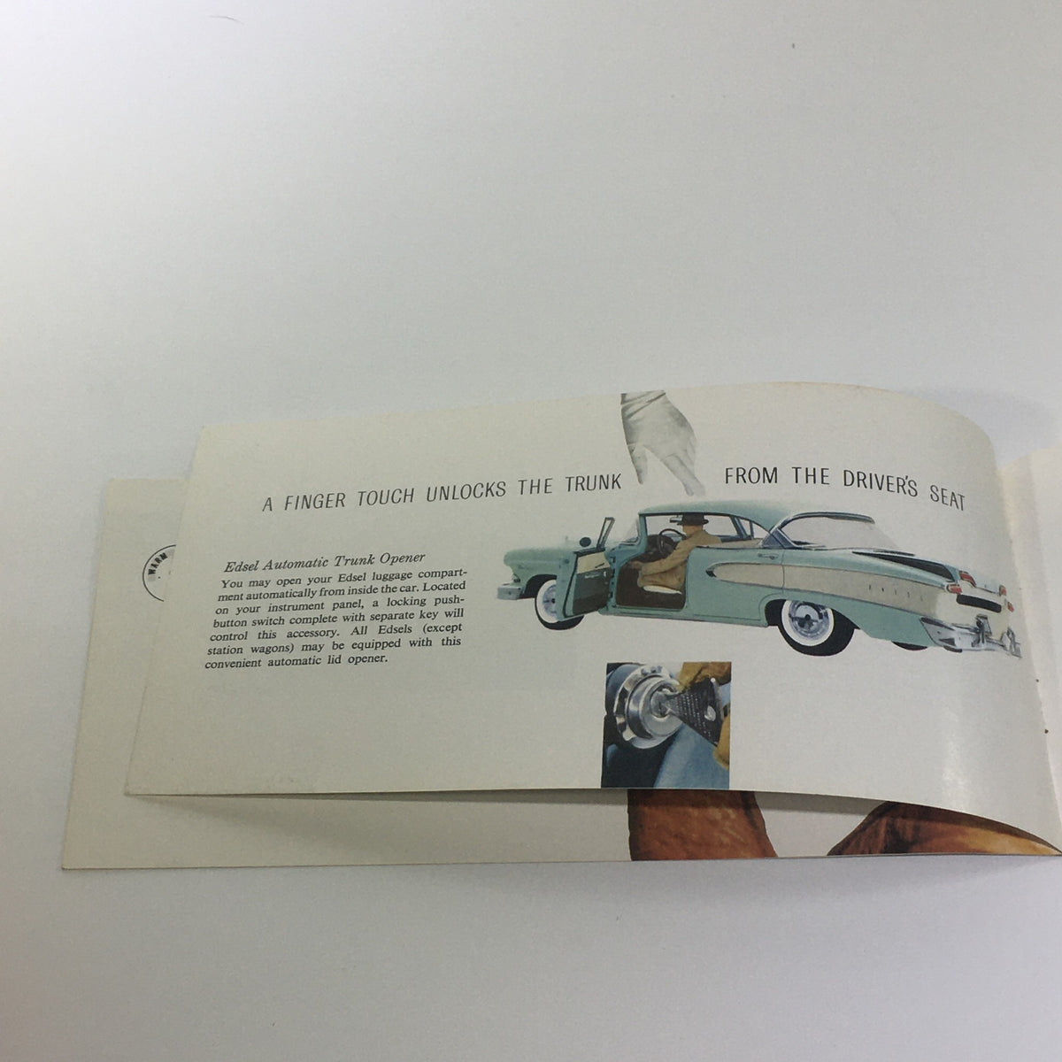 Inside view of the Vintage 1958 Ford Edsel Car dealer Catalog Brochure showcasing the Edsel Automatic Trunk Opener feature with a driver's seat perspective. Highlights the innovative design and functionality of the Edsel.