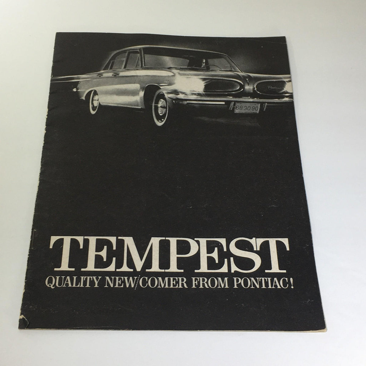 Vintage Pontiac Tempest car catalog brochure cover showcasing the phrase 'QUALITY NEW/COMER FROM PONTIAC' with a classic car image.