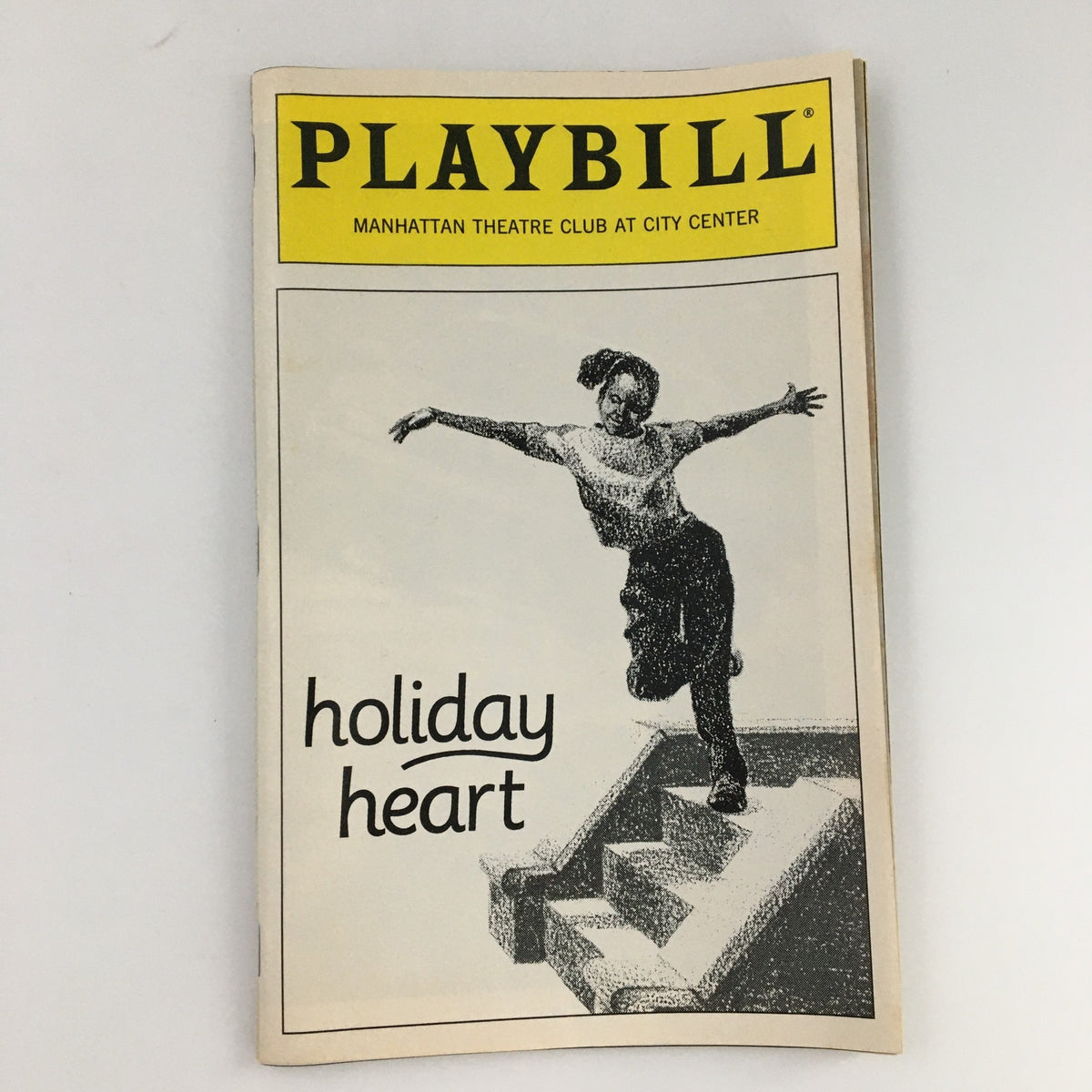 1995 Playbill for 'Holiday Heart' featuring artistic cover design, showcasing a dancer jumping on stairs, representative of the Manhattan Theatre Club production.