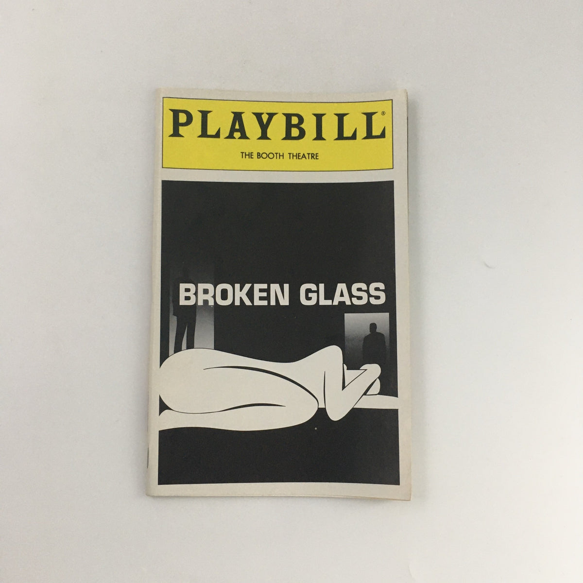 1994 Playbill for the Booth Theatre production of 'Broken Glass', featuring a minimalist cover design along with artistic black and white elements, showcasing the title prominently.