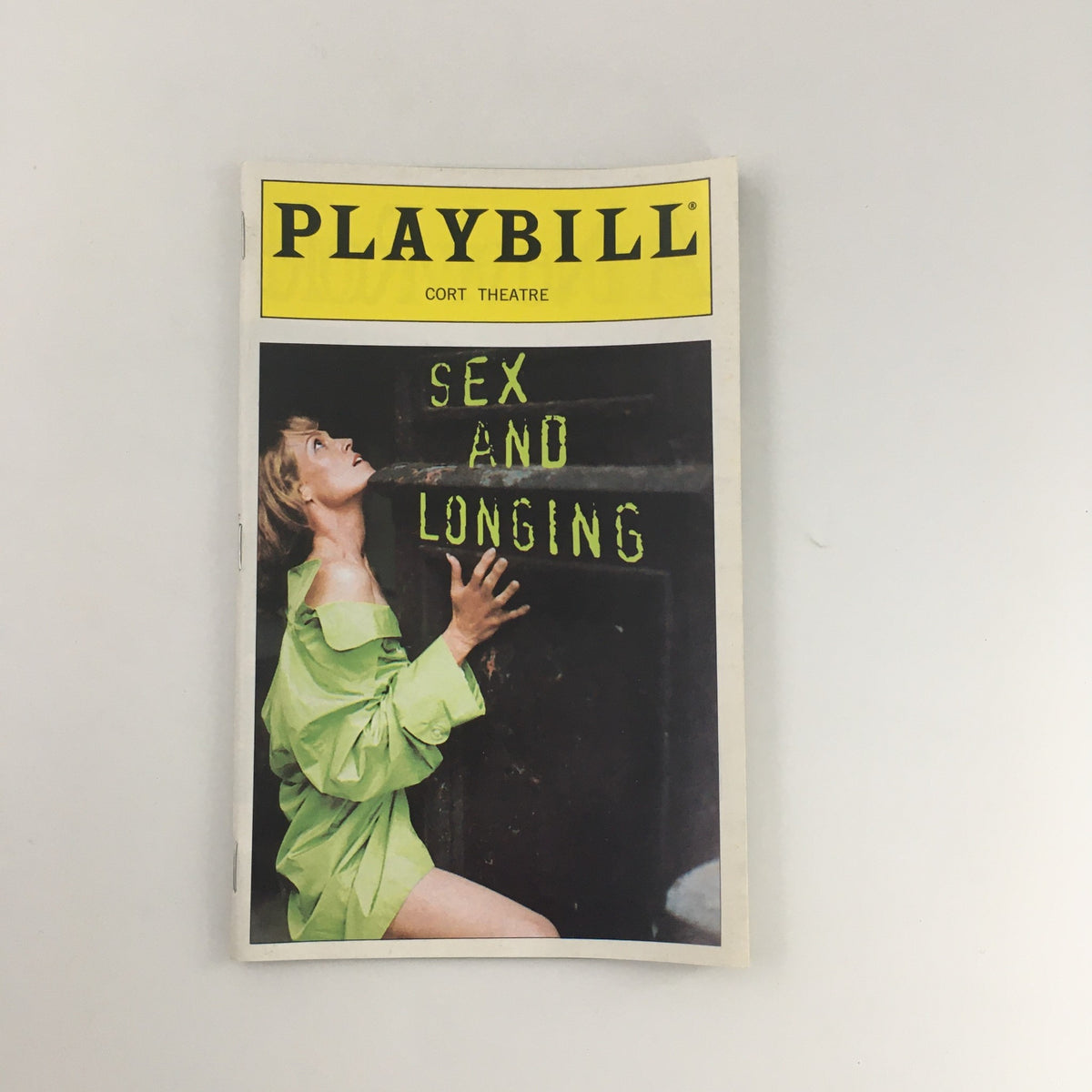 1996 Playbill from the Cort Theatre for 'Sex and Longing', featuring a striking cover image of a woman in a green outfit looking at a sign.