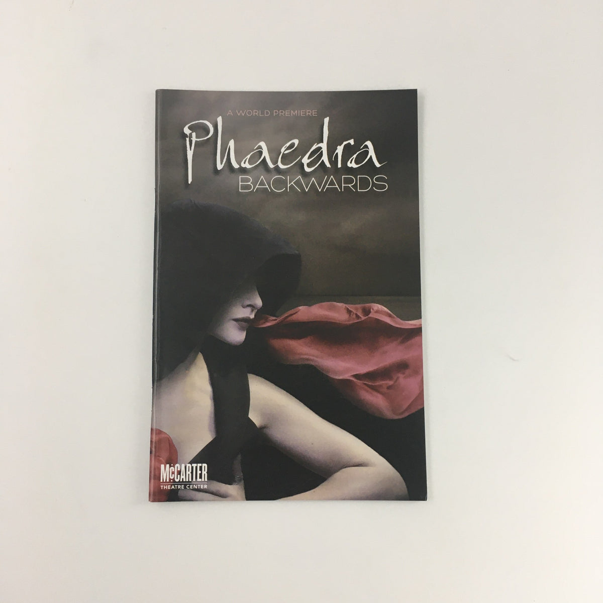 Cover of the 2011 McCarter Theatre Center 'Phaedra Backwards', featuring a woman in a hooded cloak against a dramatic background.