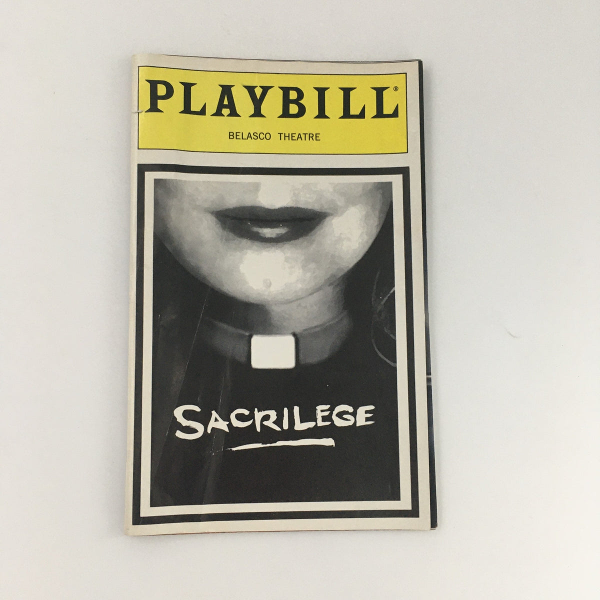 1995 Playbill for Belasco Theatre's 'Sacrilege' featuring a close-up of a character's face, highlighting the title and theatre logo.