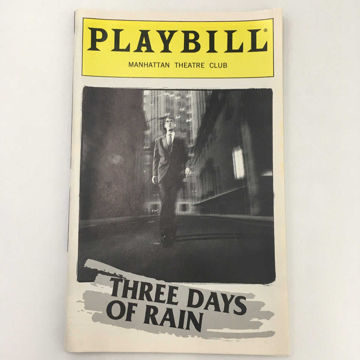 1997 Playbill for 'Three Days of Rain' by Richard Greenberg featuring a somber cover image of a man in a suit walking in an urban setting, presented by Manhattan Theatre Club.