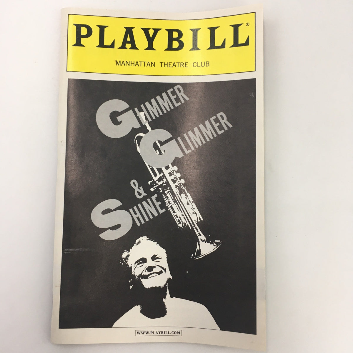 2001 Playbill for Glimmer, Glimmer & Shine by Warren Leight, featuring a striking black and white cover design with an image of a smiling man and trumpet.