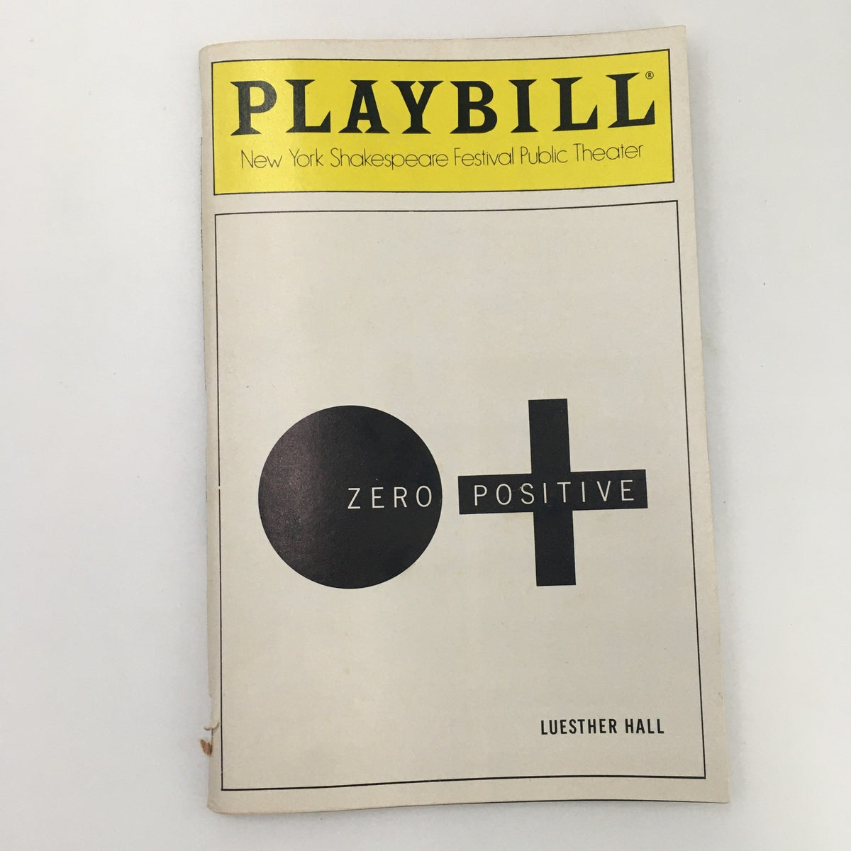 1988 Playbill for 'Zero Positive' at the Public Theater's LuEsther Hall, featuring a minimalist design with a black circle and plus sign, reflective of late 80s theatrical aesthetic.