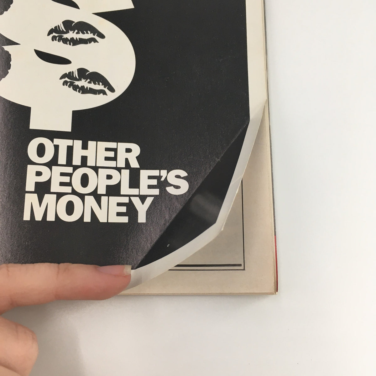 Close-up of the corner of a 1989 Playbill for 'Other People's Money' featuring a protective covering, showcasing vintage theater memorabilia from the Minetta Lane Theatre.